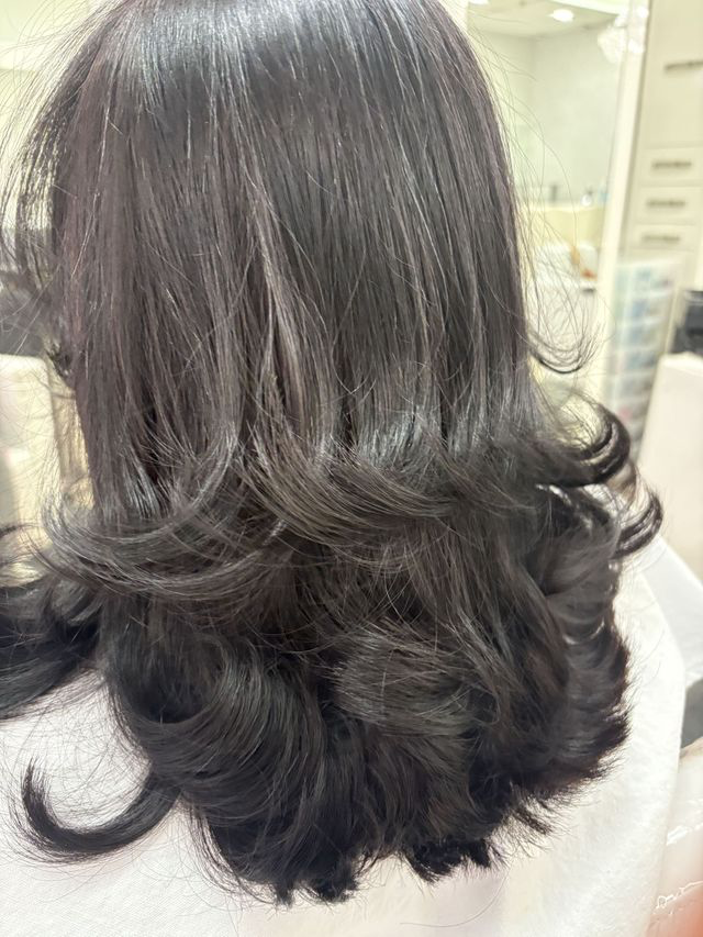 Dark brunette layered blowout with curled ends